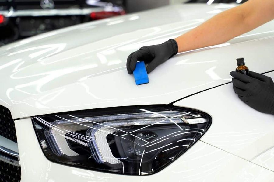 Ceramic coating being hand-applied to a headlight and hood