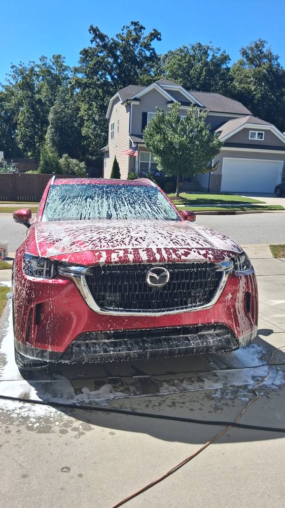Snow foam being applied to a customer's SUV in their own driveway